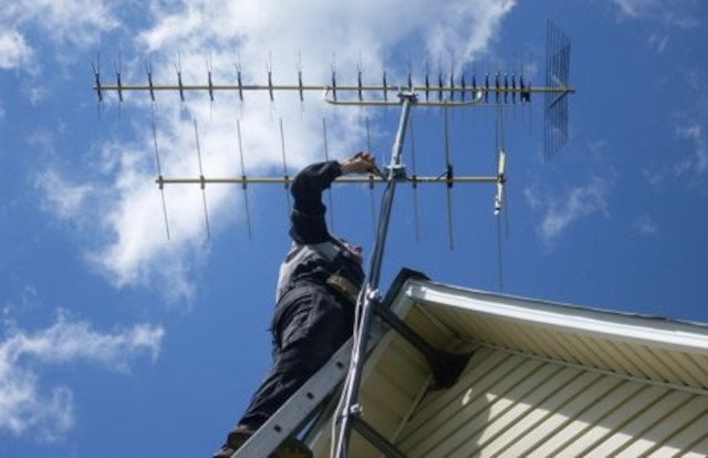 antennista posiziona antenna e controlla i livelli.